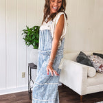 Vintage light wash denim and twill overalls with silver metal adjustable strap hardware, side zip, side and back pockets with ivory eyelet trim and cutouts throughout, wide leg design.