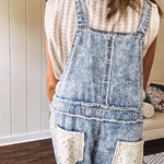 Vintage light wash denim and twill overalls with silver metal adjustable strap hardware, side zip, side and back pockets with ivory eyelet trim and cutouts throughout, wide leg design.