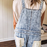 Vintage light wash denim and twill overalls with silver metal adjustable strap hardware, side zip, side and back pockets with ivory eyelet trim and cutouts throughout, wide leg design.
