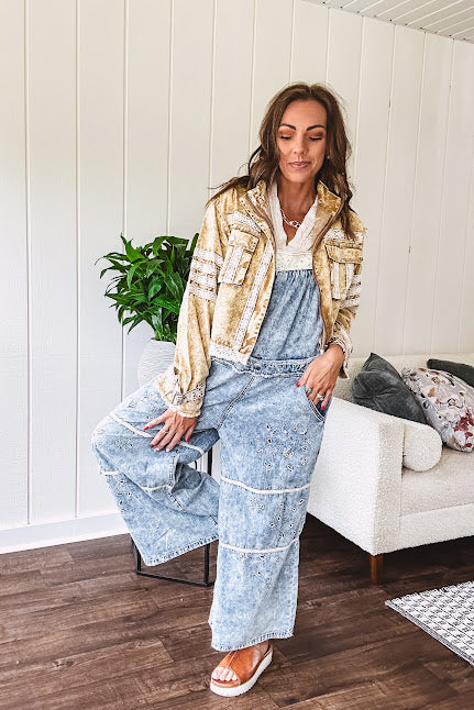 Vintage light wash denim and twill overalls with silver metal adjustable strap hardware, side zip, side and back pockets with ivory eyelet trim and cutouts throughout, wide leg design.