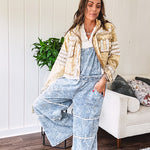 Vintage light wash denim and twill overalls with silver metal adjustable strap hardware, side zip, side and back pockets with ivory eyelet trim and cutouts throughout, wide leg design.