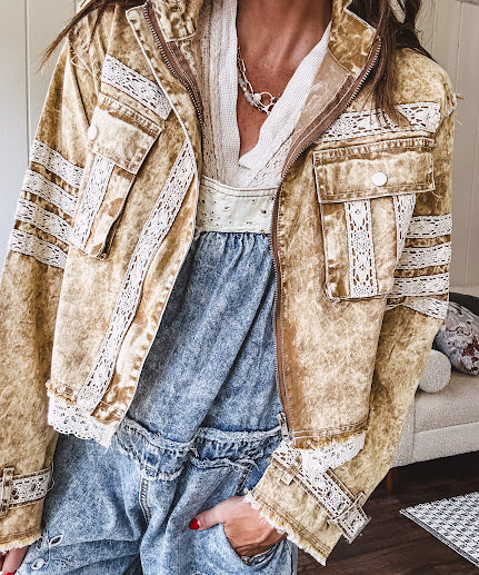 Lightweight antique bronze washed zip up denim jacket with exposed seams, ivory lace detail throughout, 3D pockets on the front, strap adjustable cuffs and lace trim at the hem.