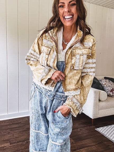 Lightweight antique bronze washed zip up denim jacket with exposed seams, ivory lace detail throughout, 3D pockets on the front, strap adjustable cuffs and lace trim at the hem.