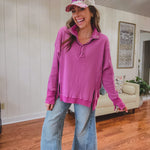 Woman wearing a pink hoodie and jeans indoors