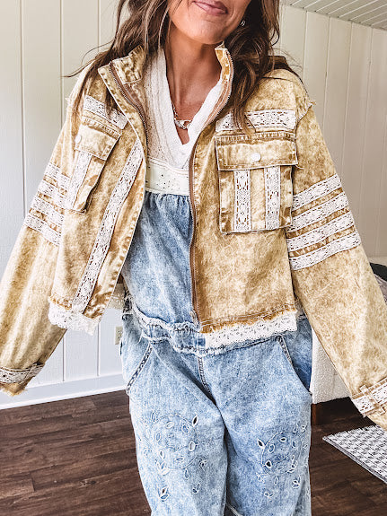 Lightweight antique bronze washed zip up denim jacket with exposed seams, ivory lace detail throughout, 3D pockets on the front, strap adjustable cuffs and lace trim at the hem.
