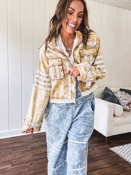 Lightweight antique bronze washed zip up denim jacket with exposed seams, ivory lace detail throughout, 3D pockets on the front, strap adjustable cuffs and lace trim at the hem.