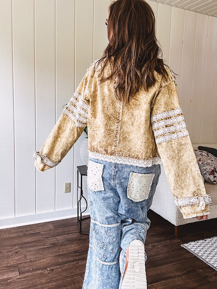 Lightweight antique bronze washed zip up denim jacket with exposed seams, ivory lace detail throughout, 3D pockets on the front, strap adjustable cuffs and lace trim at the hem.