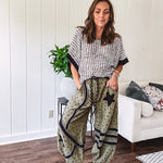 Cotton lightweight moss green joggers with mauve dainty floral print and black knit striping and star patch detail throughout, button and zipper closure with rope grommet stye belt, side pockets and elastic cuffs.