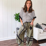 Cotton lightweight moss green joggers with mauve dainty floral print and black knit striping and star patch detail throughout, button and zipper closure with rope grommet stye belt, side pockets and elastic cuffs.