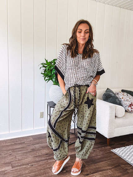 Cream and black striped open weave pullover with contrasting black trim at the short sleeve cuffs and round neck with a slouchy fit.