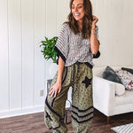 Cotton lightweight moss green joggers with mauve dainty floral print and black knit striping and star patch detail throughout, button and zipper closure with rope grommet stye belt, side pockets and elastic cuffs.