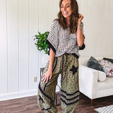 Cotton lightweight moss green joggers with mauve dainty floral print and black knit striping and star patch detail throughout, button and zipper closure with rope grommet stye belt, side pockets and elastic cuffs.