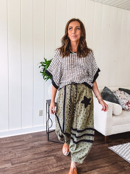 Cotton lightweight moss green joggers with mauve dainty floral print and black knit striping and star patch detail throughout, button and zipper closure with rope grommet stye belt, side pockets and elastic cuffs.