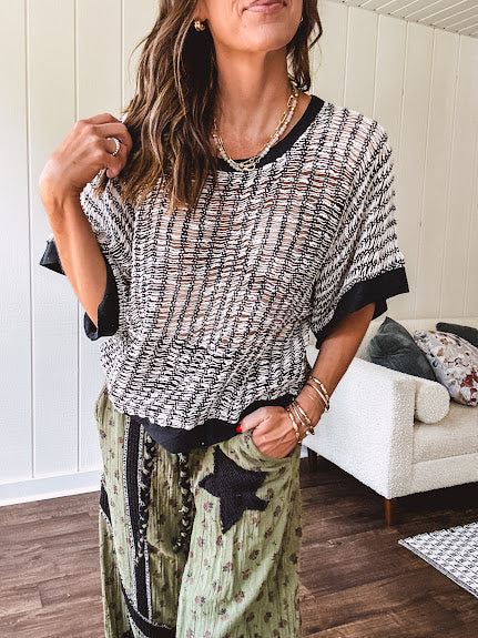 Cream and black striped open weave pullover with contrasting black trim at the short sleeve cuffs and round neck with a slouchy fit.