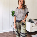 Cream and black striped open weave pullover with contrasting black trim at the short sleeve cuffs and round neck with a slouchy fit.