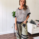 Cream and black striped open weave pullover with contrasting black trim at the short sleeve cuffs and round neck with a slouchy fit.