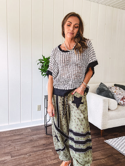 Cream and black striped open weave pullover with contrasting black trim at the short sleeve cuffs and round neck with a slouchy fit.