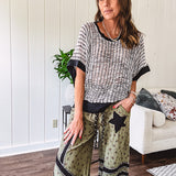 Cream and black striped open weave pullover with contrasting black trim at the short sleeve cuffs and round neck with a slouchy fit.