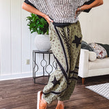 Cotton lightweight moss green joggers with mauve dainty floral print and black knit striping and star patch detail throughout, button and zipper closure with rope grommet stye belt, side pockets and elastic cuffs.