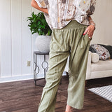 Lightweight olive smocked waist pants with side pockets and knee darts, cropped style.