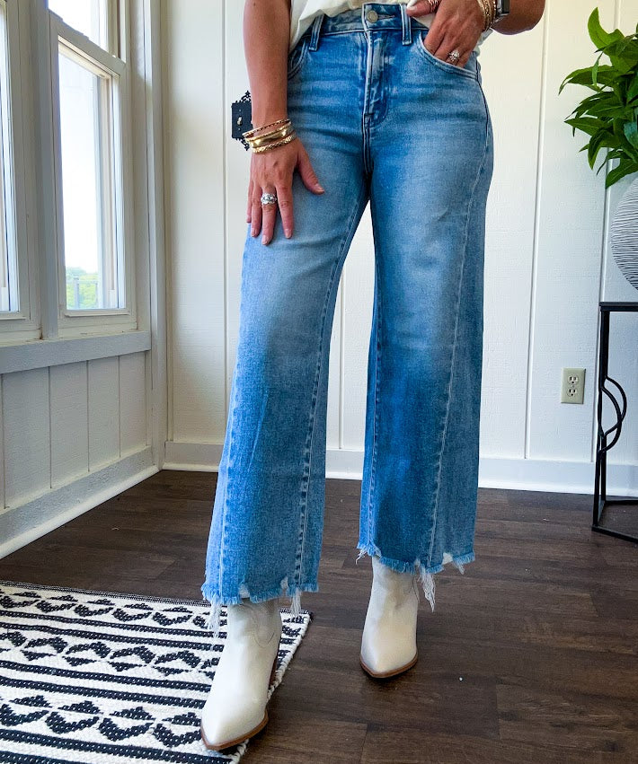 Cropped tattered hem wide leg medium wash denim jeans.