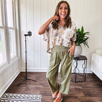 Lightweight olive smocked waist pants with side pockets and knee darts, cropped style.