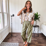 Lightweight olive smocked waist pants with side pockets and knee darts, cropped style.