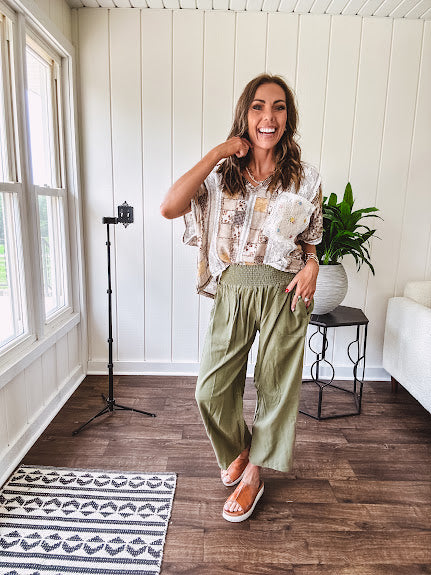 Lightweight olive smocked waist pants with side pockets and knee darts, cropped style.