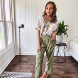 Lightweight olive smocked waist pants with side pockets and knee darts, cropped style.