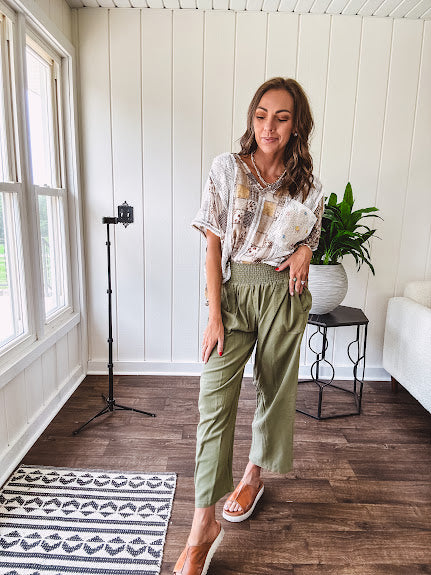 Lightweight olive smocked waist pants with side pockets and knee darts, cropped style.