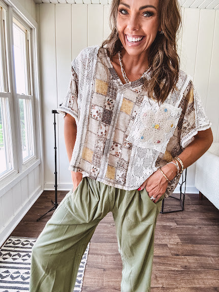 Lightweight and flowy beige patchwork printed tee with V neck, raw seams and cream lace inserts and floral crochet floral patch on the front pocket.