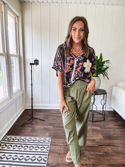 Lightweight olive smocked waist pants with side pockets and knee darts, cropped style.