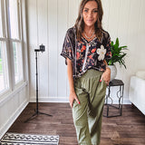 Lightweight black V neck tee with coral rose floral print throughout, raw seams and black ace inserts and ivory floral crochet patchwork on the front pocket.