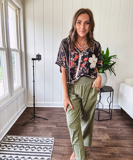 Lightweight black V neck tee with coral rose floral print throughout, raw seams and black ace inserts and ivory floral crochet patchwork on the front pocket.