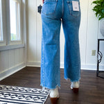 Cropped tattered hem wide leg medium wash denim jeans.