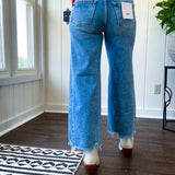 Cropped tattered hem wide leg medium wash denim jeans.