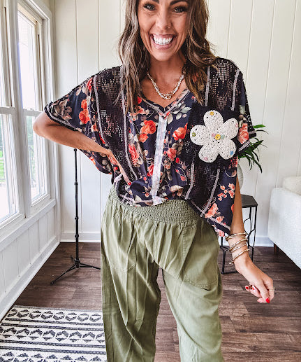 Lightweight black V neck tee with coral rose floral print throughout, raw seams and black ace inserts and ivory floral crochet patchwork on the front pocket.