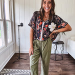 Lightweight black V neck tee with coral rose floral print throughout, raw seams and black ace inserts and ivory floral crochet patchwork on the front pocket.