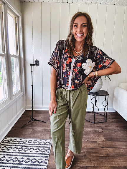 Lightweight black V neck tee with coral rose floral print throughout, raw seams and black ace inserts and ivory floral crochet patchwork on the front pocket.