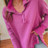 Person wearing a bright pink corduroy shirt indoors.