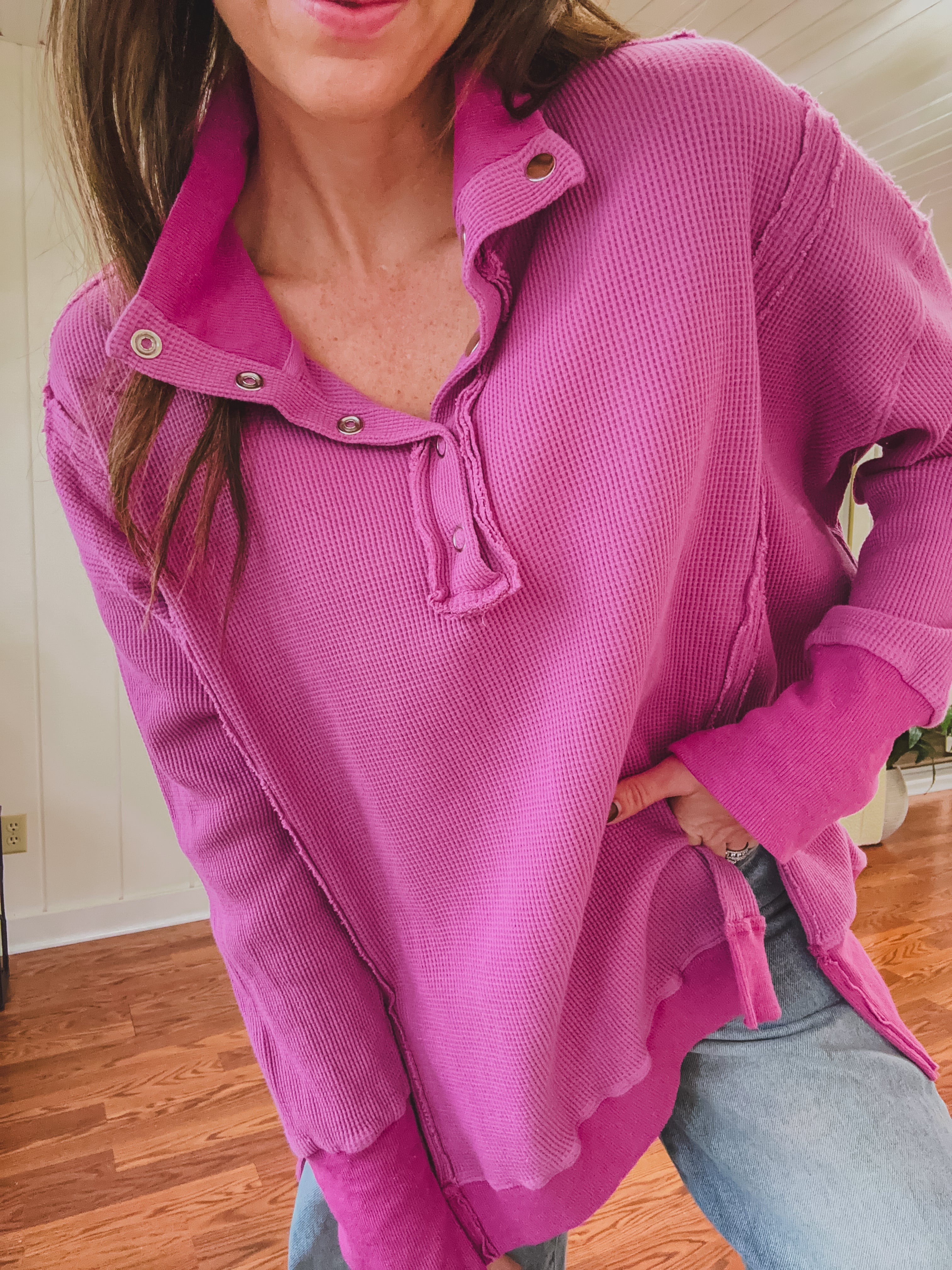 Person wearing a bright pink corduroy shirt indoors.