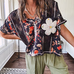 Lightweight black V neck tee with coral rose floral print throughout, raw seams and black ace inserts and ivory floral crochet patchwork on the front pocket.