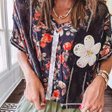 Lightweight black V neck tee with coral rose floral print throughout, raw seams and black ace inserts and ivory floral crochet patchwork on the front pocket.