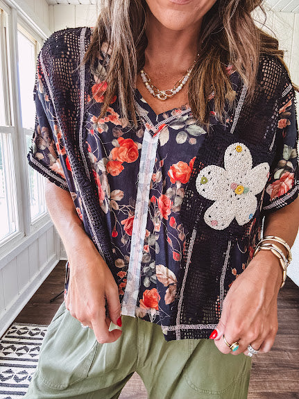 Lightweight black V neck tee with coral rose floral print throughout, raw seams and black ace inserts and ivory floral crochet patchwork on the front pocket.
