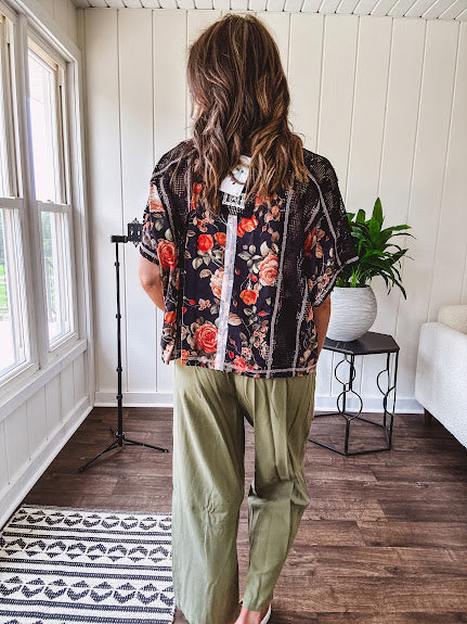 Lightweight black V neck tee with coral rose floral print throughout, raw seams and black ace inserts and ivory floral crochet patchwork on the front pocket.