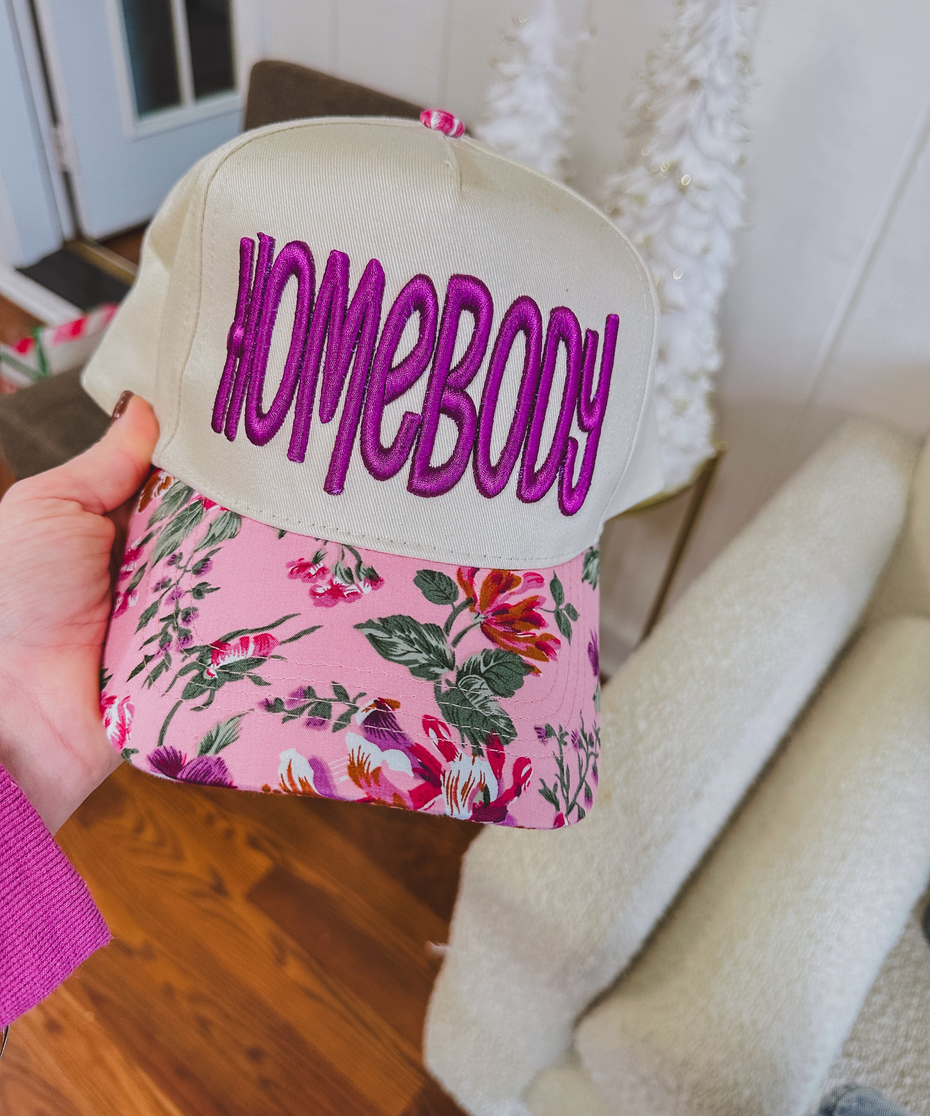 Structured trucker hat with canvas background, orchid "homebody" in thick embroidery and a floral bill.