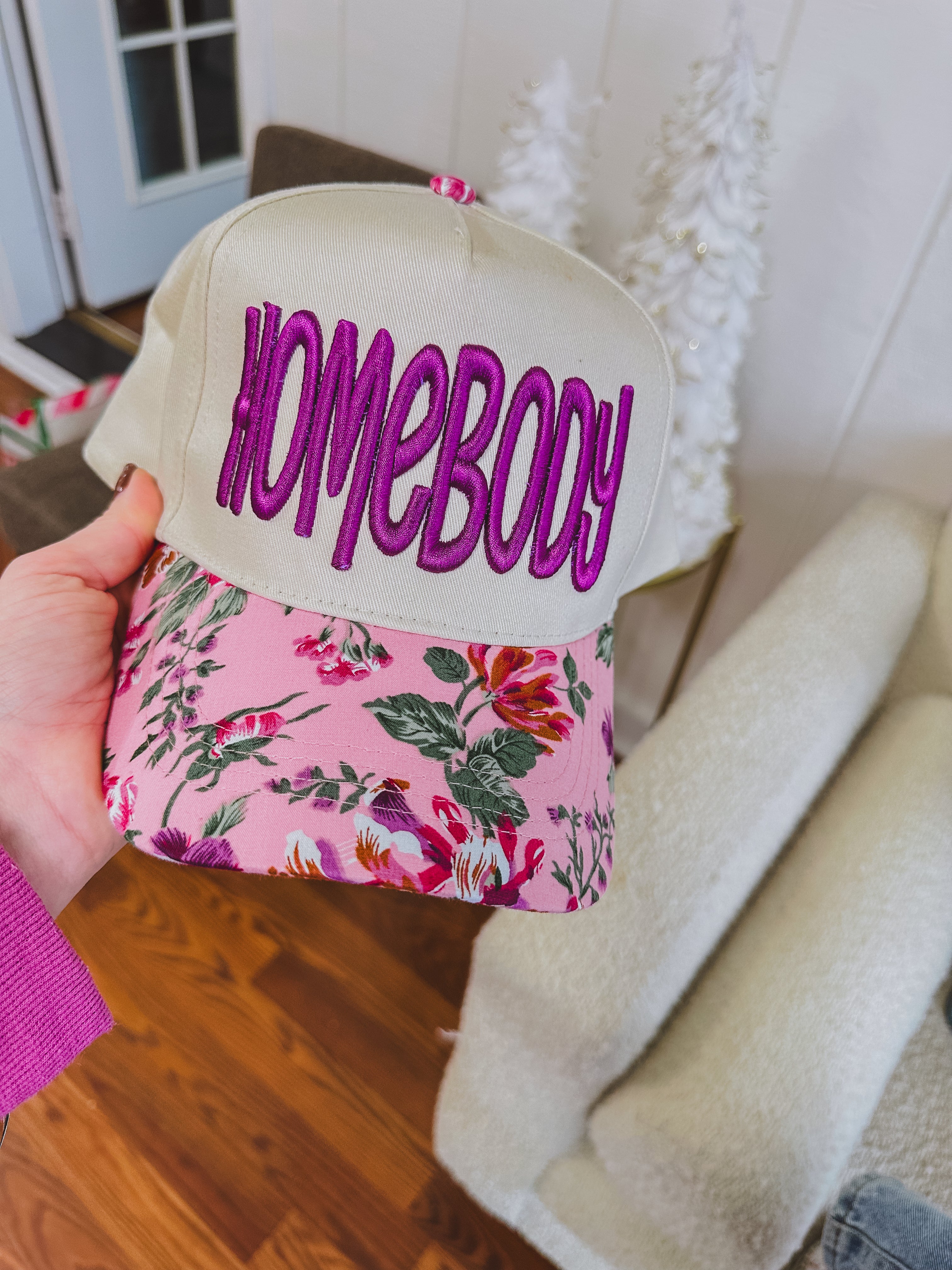 Structured trucker hat with canvas background, orchid "homebody" in thick embroidery and a floral bill.