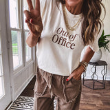 Ivory cotton tee featuring dark brown "Out of Office" and "Needing a Little Me Time Rest & Relaxation Office the Cock, 'bye!" graphics on the front and back.