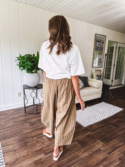 Lightweight mocha utility pant with textured darker mocha striping and contrasting tan and cream mini striping at the elastic drawstring waist and trim on the oversized pocket.