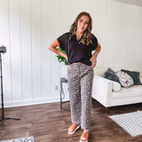 Stretchy camel colored leopard print barrel pants with side pockets, tan trim at the waist, button and zipper closure and relaxed fit.